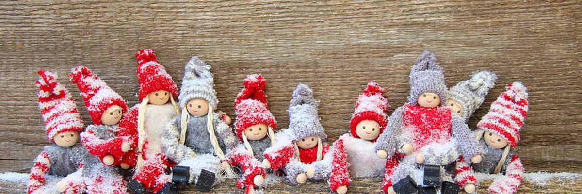 Dezembergeschichten - kleine gestrickte Trolle lehnen an einem Brett